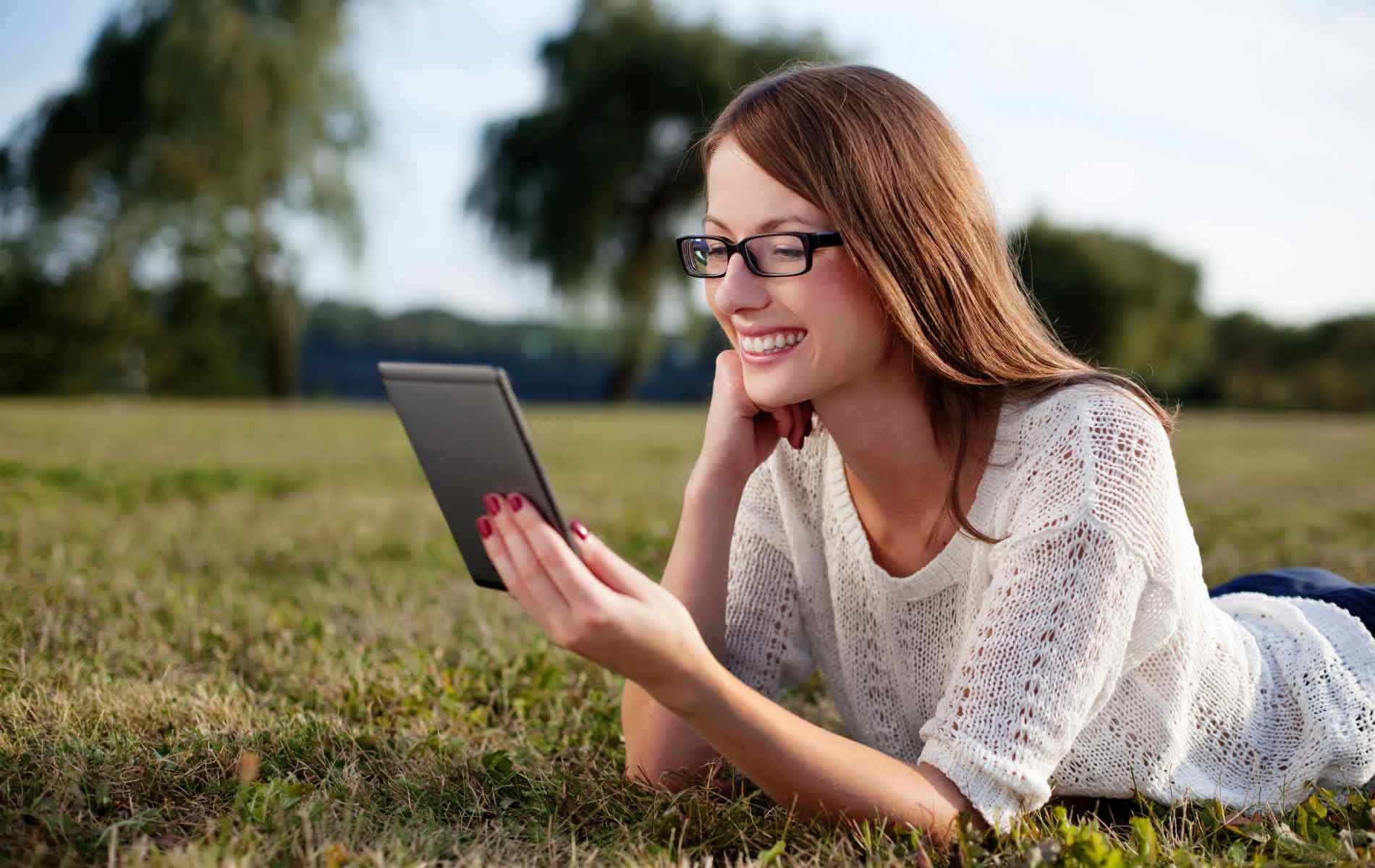 Womna reding digital book outdoors wearing Blumax lenses