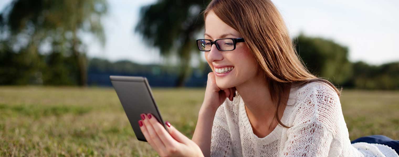 Womna reding digital book outdoors wearing Blumax lenses