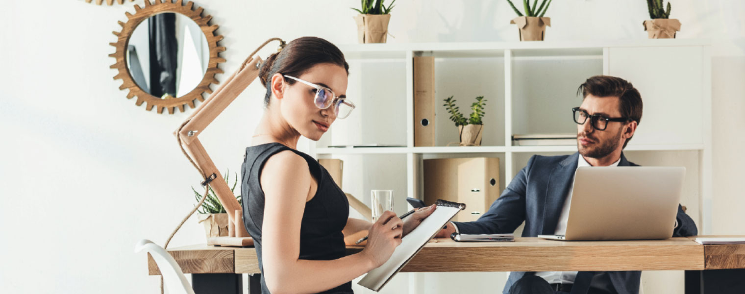 Man and woman in a office wearing glasses