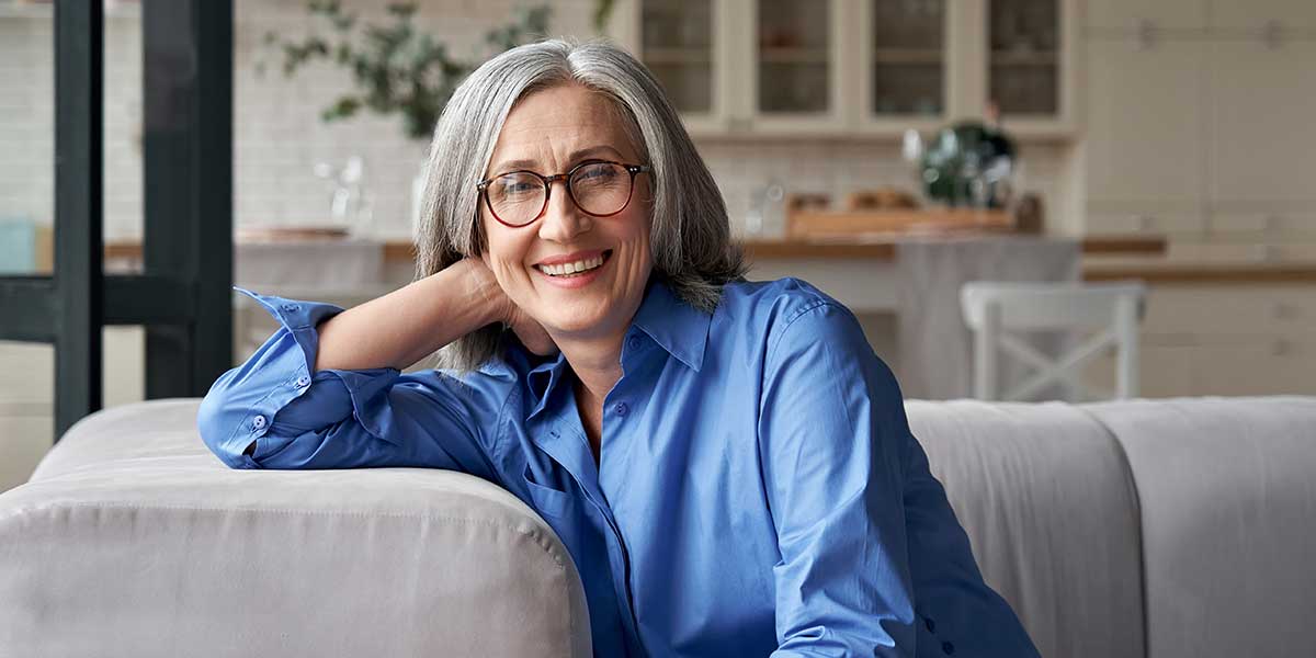 Elderly lady sitting on the sofa wearing progressive lenses.