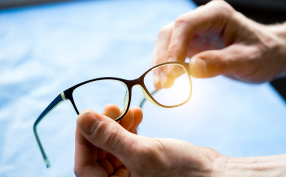 Hands cleaning glasses with cloth