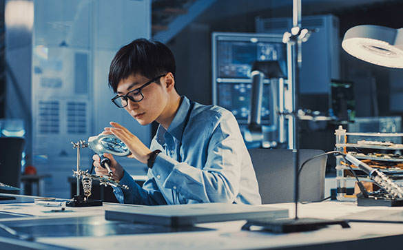 Man wering glasses soldering electronics