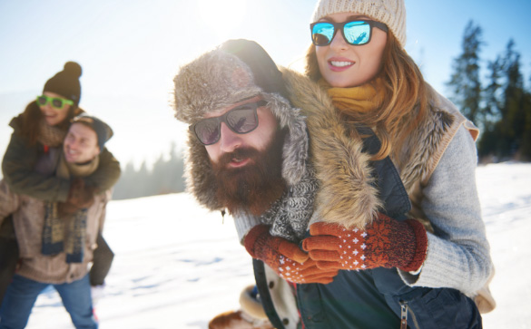 Group of people having fun in snow wearing mirror lenses